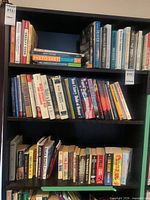 Full view of three shelves packed with assorted hardcover and paperback books