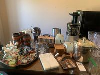 Overview of lot showing Hurom juicer, ice bucket, terracotta cups, glassware, marble board, bar tools and coasters