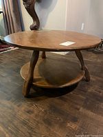 Full view of two-tier round coffee table on hardwood floor