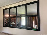 Full view of large six-pane wall mirror mounted on wall