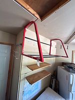 Overall view of red Motomaster tire rack mounted on wall
