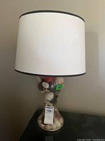 Full view of lamp showing glass base and white shade