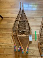 Full view of both wooden snowshoes on floor