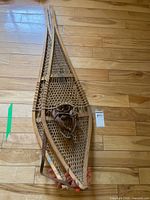 Full view of both snowshoes stacked on floor
