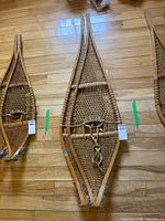 Full view of snowshoe pair on wood floor showing overall size and construction