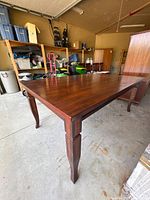 Full view of dining table angled showing cabriole legs and top wear