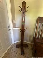 full view of wooden coat rack with hooks