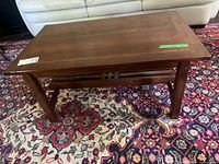 Full view of coffee table showing top, legs, slatted shelf, and finish