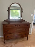 Front view of dresser showing drawers, mirror, and overall style