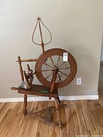 Full view of spinning wheel showing overall design and accessories on bench
