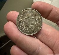Reverse side of the 1949 Canadian 50-cent silver coin showing coat of arms and date