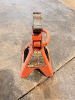 full view orange steel jack stand standing upright