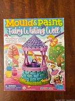 Front of 4M Mould & Paint Fairy Wishing Well kit box showing contents and design