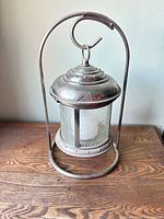 Full view of metal and glass lantern on stand