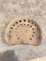 Top view of cast iron seat showing perforations and rusted surface