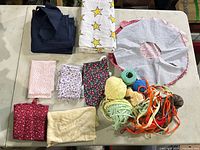 Overall lot view showing all fabric pieces, yarn balls and trim