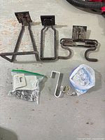 Overview showing three rubber-coated hooks, metal plate, S-hook, bags of screws/anchors