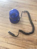 Overall view of blue dome strobe light with coiled cord and plug