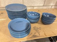 Stack of dinner and salad plates with two stacks of bowls
