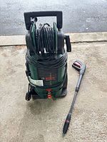Front view of Bosch pressure washer with hose reel and lance