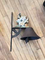 Cast iron floral wall bell showing bracket, bell and painted flower detail
