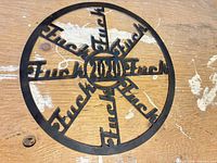 Full view of circular steel decor on wooden surface