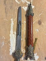 Full view of dagger and scabbard showing blade design, fittings and tassel