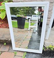 Full view of mirror standing against wall outdoors