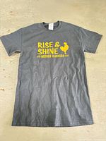 Full front view of black T-shirt with yellow slogan graphic