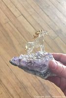 Front view of glass animal figurine on amethyst base