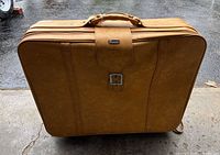 Front view of tan Holiday suitcase with latch and handle visible