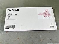 Front of sealed IKEA SNÖFINK box showing product info and pink wall decoration image
