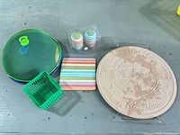 Full lot: pizza stone with rack, striped trivet, stacked shakers, mesh cover set, plastic baskets