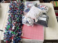 All items laid out: four bags fabric strips, two canvas sheets, finished rug