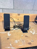 Front view of both Logitech R-10 speakers with wiring visible