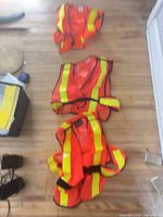 Three safety vests laid out flat showing overall design and color