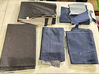 Stacked gray and indigo denim pieces on table