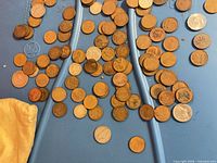 spread of mixed Canadian and US pennies and nickels on blue surface