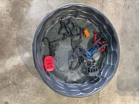 Overall lot inside black dog pool containing harnesses, muzzle, accessories