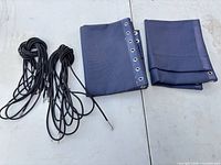 Folded navy panels and bundled black bungee cords on surface