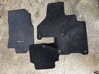 All four Nissan Rogue black carpet floor mats laid out showing overall condition and shape