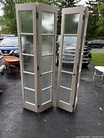 Two bifold door assemblies standing upright showing overall design and condition