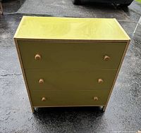 Front view of olive green dresser showing three drawers, knobs, trim