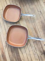 Top view showing both square pans with copper interiors and metal handles