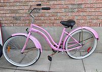 Full side view of pink cruiser bicycle with fenders and white-wall wheels