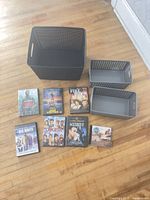 overview of large black bin, two grey baskets and media cases