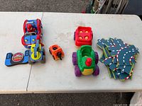 All items laid out: RC car, remote, small cars, block, foam track pieces