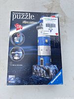 Front of original Ravensburger 3D Puzzle Night Edition box, 216 pieces, lighthouse image