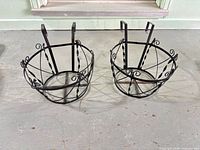 Both wrought iron hanging planters side by side showing overall form and condition