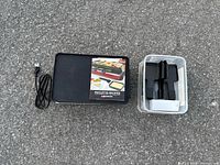 Grill, power cord, booklet and container of accessories laid out